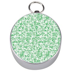 A Green And White Background With Small White Dots Silver Compasses